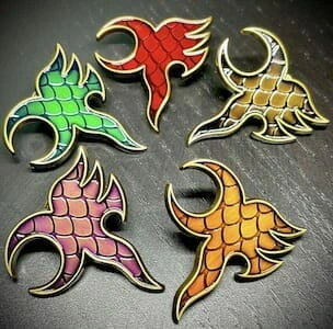 Set of six dragon-inspired lapel pins with a metallic finish and a textured, scaled pattern. Each pin has a different vibrant color, including red, green, gold, pink, orange, and bronze.