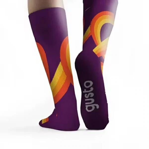 Pair of knee-high custom full-color socks with a purple background and bold, intertwined orange and yellow ribbon designs. The word 'Gusto' is printed in white along the side of one sock.