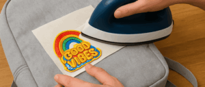 ironing on good vibes patch onto backpack