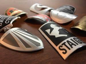 Collection of custom bicycle head badges with intricate designs, representing personalized bike accessories, branding, and craftsmanship in custom metalwork.