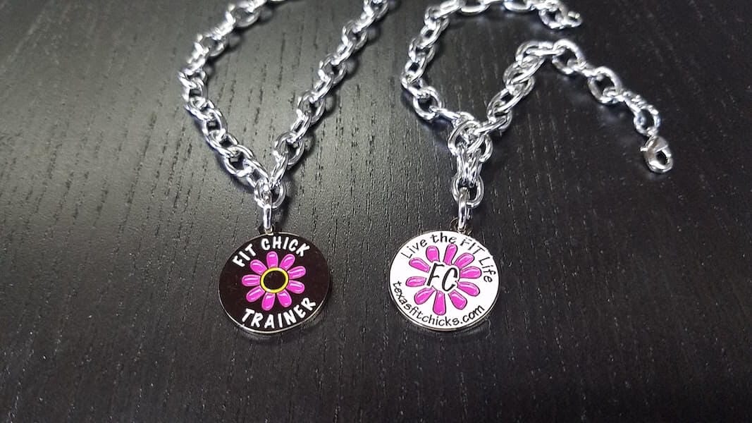 silver neckless with pink flower on it