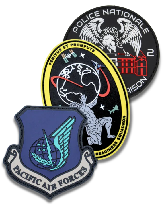 Set of three custom PVC military and law enforcement patches. The front patch represents the 'Pacific Air Forces,' featuring a blue shield design with a winged emblem, globe, and lightning bolt. The middle patch has a space-themed design with an astronaut reaching towards Earth, a satellite, and a red orbit line, encircled by the words 'Readiness Squadron' and 'Peritus Et Promptus.' The back patch is circular, black with white and red details, displaying an eagle and the text 'Police Nationale' and 'Maison 2,' alongside an illustration of a building.