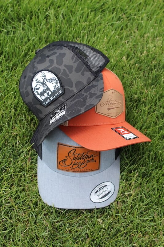 three trucker styles hats on grash