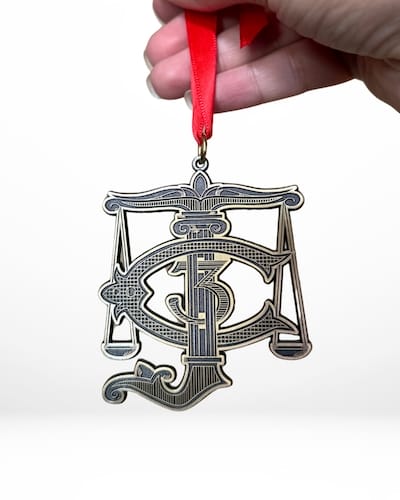 custom bronze metal ornament with red ribbon